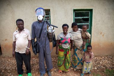 IRS spray operator with family during IRS campaign, Rwanda, 2014