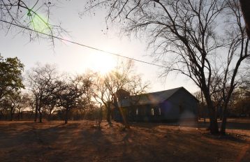 Sun shining down on a building in a rural landscape with trees in Zimbabwe