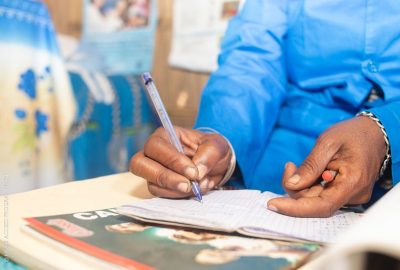 Image of hands using a pen to complete a form