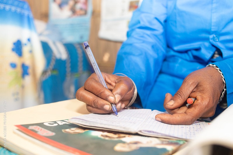 Image of hands using a pen to complete a form